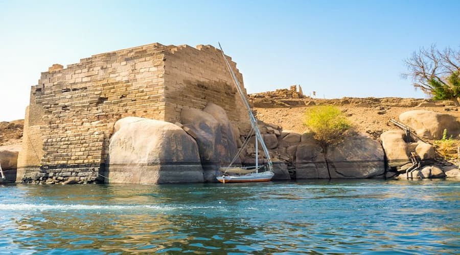 Aerial view of Elephantine Island on the Nile River with lush greenery and ancient ruins in Aswan